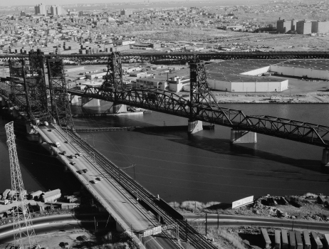 Aerial view of the PATH transit system bridge looking southeast. To the left are the Newark turnpike and the Conrail bridge. The Pulaski Skyway is in the background