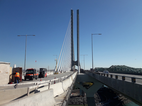 New Samuel de Champlain Bridge in Montreal : The central bridge, a railway bridge, under construction. It passes through in between the legs of the characteristic tower of the New Champlain Bridge. On the right, four-lane road traffic has already been flowing for three years.