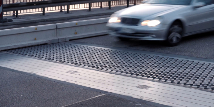The installed expansion joint with traffic passing over. The rhomboid plates reduce the noise of the vehicles
