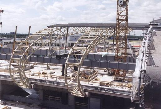 Bâtiment central de l'aéroport Düsseldorf International : Construction des poutres en treillis par dessus les rails du monorail SkyTrain