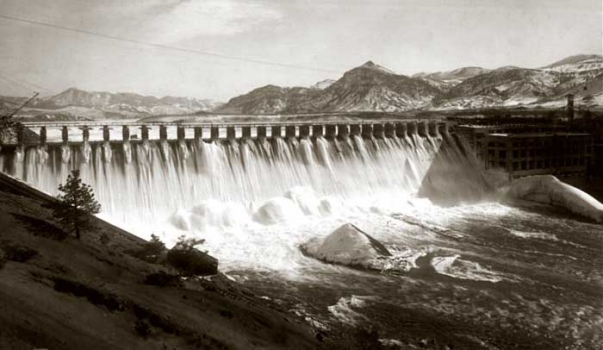 Looking roughly south at en:Holter Dam in 1918, shortly after its completion. Holter Dam is located in Lews & Clark County, Montana, United States. The dam powerhouse is on the right in the deep shadow. The metal structure holding the flashboards is visible at the crest of the dam. All the flashboards have been removed, allowing water to overflow the dam