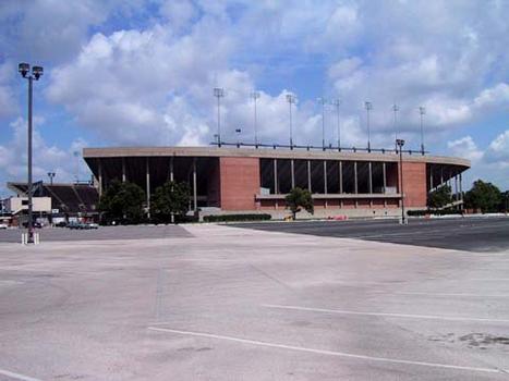 Rice Stadium : East stands from parking lot. Image not true to original; concourse has been closed in for temporary off-site book storage for the university library. It is planned to be emptied this year (2004), but there is no guarantee the enclosed, air-conditioned space will be returned to open stadium concourse