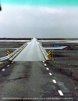 SKEIDARARSANDUR (désert de sable entre le glacier Vatnajökull et le mer, région sud) – Pont de la rivière Skeidara, emporté (avec 10 km de la route n° 1) par la «crue glaciaire» du Vatnajökull, en novembre 1996 (la plus importante du siècle), il a été reconstruit sensiblement à l'identique: voie unique, poutres métalliques en I supportant le tablier