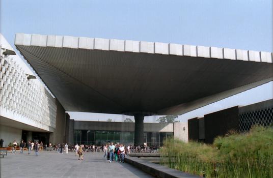 Musée National d'Anthropologie (construction 1963-1964). Le «PARAPLUIE» - Cette structure, qui recouvre le patio central, est supportée par un pilier unique en béton armé. D'un poids de 1640 t, elle est constituée d'acier et d'aluminium, ses dimensions sont exceptionnelles: 82 mètres de long sur 54 mètres de large, les bords surplombent l'esplanade de 16,80 mètres