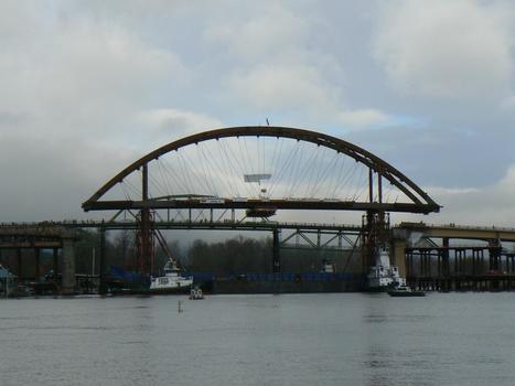 Mounted on a barge, the tied-arch main span of the new Sauvie Island Bridge approaches it's final position
