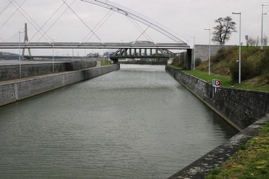 Monsin-Schleuse. Unteres Schleusenbecken in Richtung Monsin-Kanal und Maas. Man sieht vorne im Bild die Brücke Milsaucy, dahinter die Eisenbahnbrücke Monsin und links hinten den Pont de Wandre