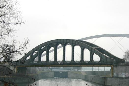 Die Eisenbahnbrücke der Monsininsel mit der Monsinschleuse, die Brücke kreuzt das untere Schleusenbecken welches zur Maas und zum Kanal von Visé führt