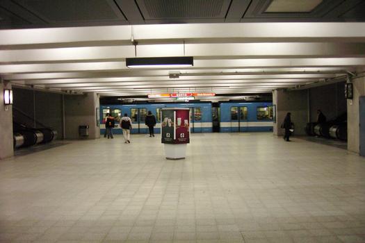 Accès au niveau de la ligne Verte (rame de métro); les escaliers mécaniques à gauche et à droite accèdent aux différents quais de la ligne Orange qui est située juste au dessus