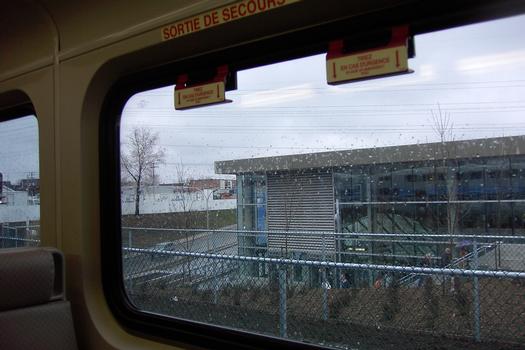Station De-La-Concorde; Côté Ouest de l'édicule, vue depuis le train en partance pour Saint-Jérôme. En bas à gauche de la fenêtre du train, on voit le boulevard De-La-Concorde passant sous le viaduc de la gare inter-modale du train de banlieue. 30/31 Ligne Orange, Métro de Montréal sur le territoire de Laval