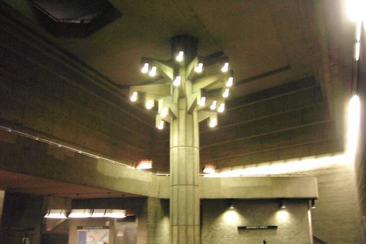 Station Georges-Vanier; Gros plan sur la grande salle et son arbre de béton. En haut à gauche, ce qui semble une tache foncée, c'est le parapet d'un balcon du niveau mezzanine, laissant voir d'en hautaux passants, les profondeurs de la station. 12/31 Ligne Orange Métro de Montréal