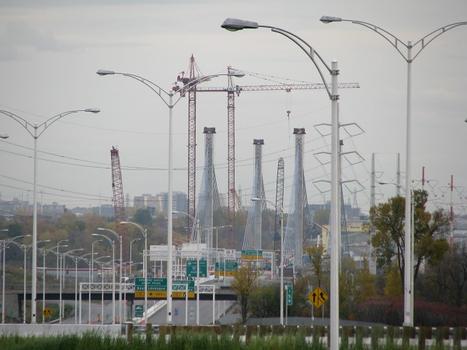 Un aperçu du chantier du pont à deux kilomètres au loin. Vue prise au téléobjectif depuis le nouvel échangeur Saint-François à Laval, établissant la jonction entre l'autoroute 25 L-H Lafontaine et l'autoroute 440 de Laval