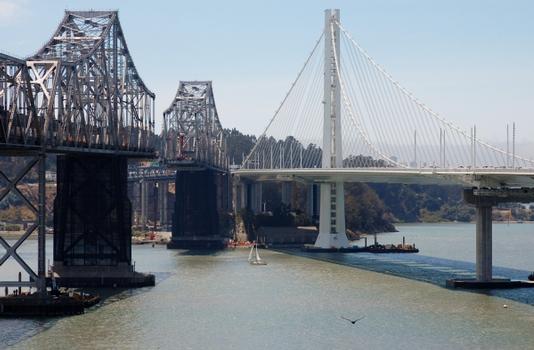 Old and new side by side. The Old East Span being dismantled on the left. The New East Span on the right