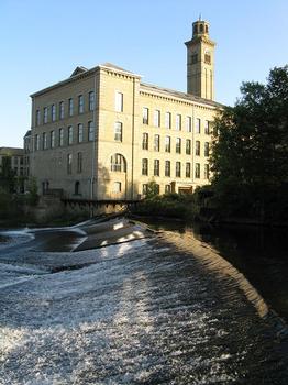 North West corner of New Mill, Saltaire taken over a weir on the River Aire