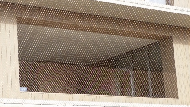 Die größere Maschenweite von 70 mm ab Brüstungshöhe bis zur Deckenkante erhöht die Transparenz des Fassadennetzes.
: Die größere Maschenweite von 70 mm ab Brüstungshöhe bis zur Deckenkante erhöht die Transparenz des Fassadennetzes.