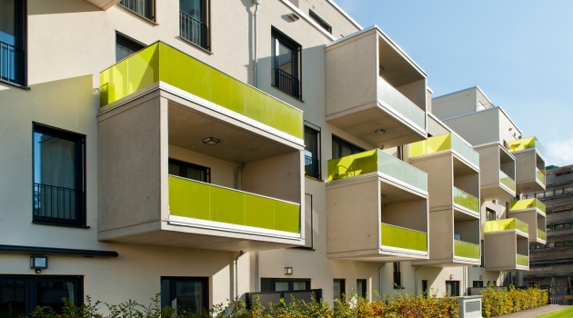 Ein besonderes Merkmal der Fassade sind die Balkone mit grün eingefärbter Glasbrüstung, die wie Rahmen auf die Fassade gesetzt sind.
: Ein besonderes Merkmal der Fassade sind die Balkone mit grün eingefärbter Glasbrüstung, die wie Rahmen auf die Fassade gesetzt sind.