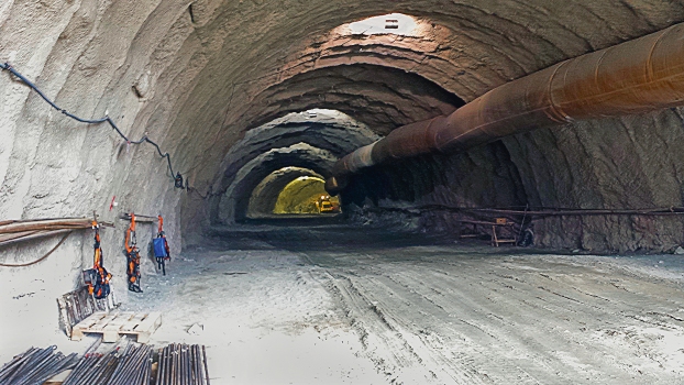 The elongated interior of one tunnel; rock bolts are visible in the left foreground.