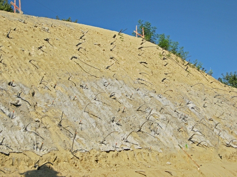 Soil nails secure the safety mesh in the upper slope section.