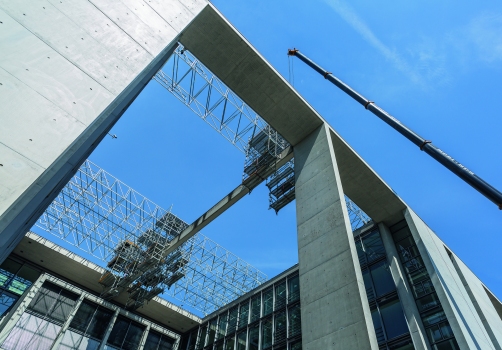 Für Sanierungsarbeiten an exponierten Betonbindern überspannt ein verfahrbares Hängegerüst die Dachlandschaft des Berliner Bundestagsgebäudes.