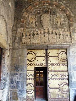 Le Puy-en-Velay - Cathédrale Notre-Dame - Porche Saint-Jean - Porte donnant sur le bras nord du transept. Les vantaux ont conservé leurs pentures romanes. C'est la seule porte historiée de la cathédrale. Le linteau représente la Cène. Sur le tympan se trouvait le Christ entouré de deux anges