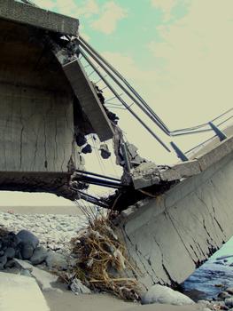 Saint-Pierre - Pont aval de la rivière Saint-Etienne effondré. On voit la précontrainte extérieure qui a arraché une partie du hourdis supérieur à droite et a fait fissrer le hourdis inférieur à gauche