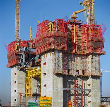 Die 4,70 m hohen Regelgeschosse der beiden Kerne des Torre Repsol stellt die Baustelle im planmäßigen Wochentakt fertig. Im Bereich der Aufzugschächte weist die PERI ACS Klettereinheit vom Aufnahmerahmen für den Betonverteiler bis zur untersten, abgehängten Nachlaufbühne für die Stahl-Einbauteile eine Gesamthöhe von immerhin 25 Metern auf