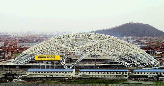 La toiture mobile du stade Nantong, une construction en acier de 2 200 tonnes, s'ouvre et se ferme à l'aide de l'hydraulique. Cette photo, prise pendant les essais, montre la toiture en position de fermeture. La fermeture de la toiture dure de 20 à 30 minutes