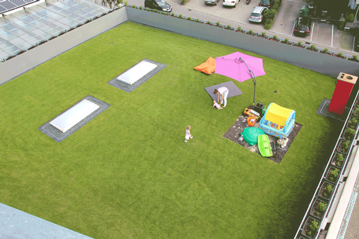Eine schöne Rasenfläche zum Entspannen, Spielen und Genießen entstand auf dem Dach dieser Lagerhalle, an welche das neue Wohngebäude angrenzt
