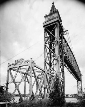 VIEW OF SOUTHEAST TOWER AND PORTAL, CENTER SPAN IN MOTION, BEING LOWERED - Cape Cod Canal Lift Bridge, Spanning Cape Cod Canal, Buzzards Bay, Barnstable County, MA (HAER MASS,1-BUZBA,1–3)
