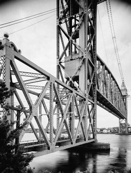 DETAIL, VIEW OF SOUTHEAST TOWER AND PORTAL, CENTER SPAN IN MOTION, BEING LOWERED - Cape Cod Canal Lift Bridge, Spanning Cape Cod Canal, Buzzards Bay, Barnstable County, MA (HAER MASS,1-BUZBA,1–4)