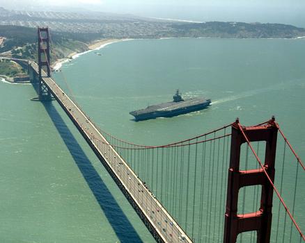 An aerial port bow view of the nuclear-powered aircraft carrier USS Abraham Lincoln (CVN-72) about to pass under the Golden Gate Bridge as the ship enters San Francisco Bay from the Pacific