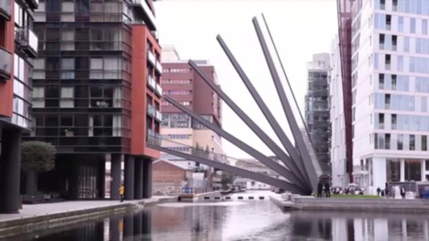 Timelapse: Fan Bridge, Merchant Square Paddington:This stunning footbridge by Knight Architects arrived at Merchant Square Paddington in August 2014. It rises gracefully to allow boats to access the head of Paddington Basin. 
Commissioned through a competition by European Land and Property, the three-metre-wide cantilevered moving structure spans 20 metres across the head of the Basin, rising by means of hydraulic jacks - an action similar to that of a traditional Japanese hand fan. The deck of the Fan Bridge is made of five beams, which came to Paddington by barge. The beams each open in sequence, with the first rising to an angle of 80 degrees; the four rising to lower levels.
The Fan Bridge rises every Wednesday and Friday just after noon, and on Saturdays at 2pm.