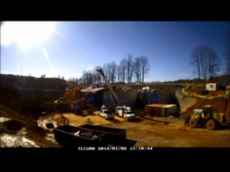 Twin Box Tunnels - Liberty University, Lynchburg, Virginia:Welcome To Brierley Associates You Tube Site! You may learn more about Brierley Associates and how we "Create Space Underground" by visiting our website
www.brierleyassociates.com
The video you will be viewing is a time-lapse of the South Tunnel Installation at Liberty University,Lynchburg,Virginia. 
This project, designed and managed by Brierley Associates, and constructed by Southland Contracting, is located on the campus of Liberty University on Regents Parkway north of the intersection with Williams Stadium road on the west side of the campus. 
The entire project consists of two side by side 2,100 ton,16 foot high, 28 foot wide, 130 foot long cast on-site reinforced concrete box tunnels. Once completed, the tunnels will convey four lanes of vehicular traffic beneath active rail lines operated by Norfolk Southern. The tunnels will provide access to Liberty University from Ward Road at the intersection with Harvard Street and will benefit the University as expansion of campus facilities is underway 
Although conventional construction of these types of tunnels is by jacking, a novel approach was selected to pull the first box through the existing railroad embankment via post-tensioning tendons installed through the embankment and walls of the tunnels. The six 840 ton capacity jacks were mounted on four foot thick reinforced concrete blocks, cast against a 23 foot high soldier pile reaction wall located at the receiving side of the embankment. The tunnel was jacked to within 35 foot of the reaction wall and was day-lighted during demolition of the reaction wall.
Elements of this project include installation of temporary excavation support systems to construct the launching and receiving areas; geotechnical instrumentation to monitor ground deformations; control of ground loss at the heading and deformation mitigation of the railways via spiles placed using trenchless technology; installation of conduits through the embankment to protect post-tensioning tendons; construction of a reinforced concrete launching pad and four reaction blocks at the receiving area.
Work to launch and jack the second (north) box tunnel began on January 6, 2014 and the drive of the 130 ft long box was successfully completed during the early evening hours of Thursday, January 9, 2014. Brierley's Project Manager and Resident Engineer, Jeremiah Jezerski and Brierley's President AJ McGinn both extend their congratulations to Clay Griffith of Southland Contracting for a job well done and managing the challenges of this project.
