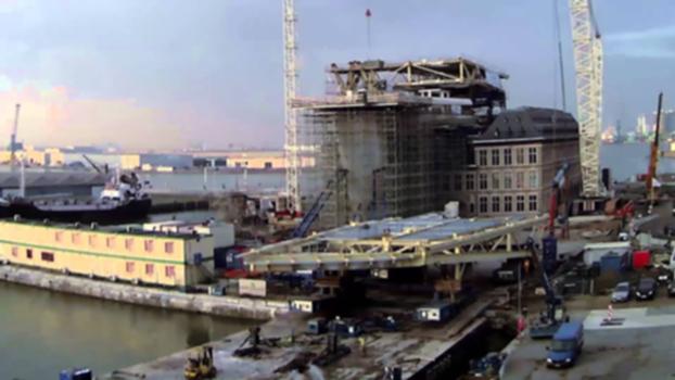 The making of the new Port of Antwerp Port House - pt 2:In this video you can watch the placement of the second module on the new Port of Antwerp Port House, a design by the architect Zaha Hadid. 
Read more here:
http://www.portofantwerp.com/en/news/steel-structure-takes-shape-above-new-port-house 
http://www.portofantwerp.com/en/news/top-architect-zaha-hadid-launches-construction-new-port-house