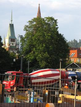 Betonierung der Freiburger Kronenbrücke, Fahrmischer mit Martinstor und Münsterturm im Hintergrund