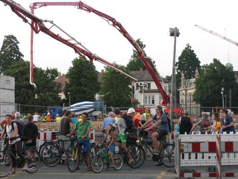 Betonierung der Freiburger Kronenbrücke, Schaulustige und Radfahrer am Überweg