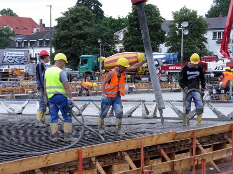 Neubau der Kronenbrücke in Freiburg:Arbeiter beim Betonieren der Freiburger Kronenbrücke und Verdichten mittels Innenrüttler