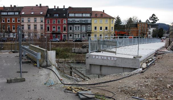 Neubau der Kronenbrücke in Freiburg:Die neue Kronenbrücke in Freiburg mit Geländer, am linken Bildrand ist die Rampe zur entfernten Behelfsbrücke zu sehen und am gegenüberliegenden Ufer das Widerlager