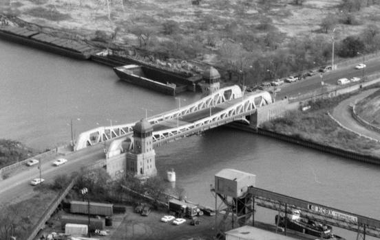 The 100th Street Bridge, in Chicago – aerial view from the southwest:The bridge is a 1927 double-leaf bascule bridge carrying East 100th Street over the Calumet River.