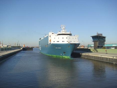 Das Autotransportschiff Auto Bank ist gerade in die Kaiserschleuse gefahren, um den Hafen von Bremerhaven zu verlassen. Im Hintergrund schließt sich das Binnenhaupt der Schleuse