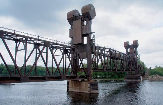 The BNSF Railway bridge in Prescott, Wisconsin, with its vertical-lift span raised part-way : The bridge was built in 1984 to replace a swing bridge at the same site.
