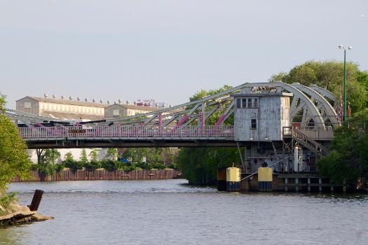 View from Water Taxi to North Avenue, looking looking north at the western Division Street bridge and the Morton Salt plant, in Chicago, Illinois : Until 2014, this bridge was one of two almost-identical bascule bridges on West Division Street, but the eastern bridge was dismantled in 2014 and replaced by a temporary bridge until a new fixed-span bridge is completed. The west bridge, built in 1904, crosses the North Branch of the Chicago River (whereas the east bridge on the same street crosses over the North Branch Canal).