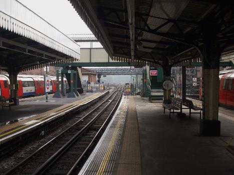 Golders Green tube station centre track served by both platforms looking south : This is bi-directional track used by terminating trains, but occasionally by through trains also. The tunnel portals south of the station are visible in the distance through the mist. The footbridge is for staff use only.