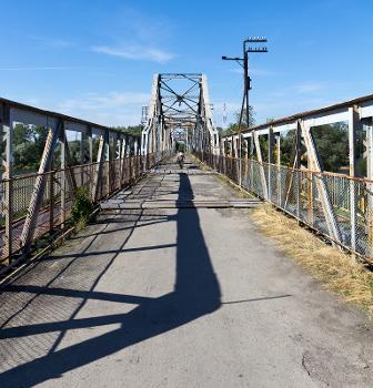 Alte Eisenbrücke in Halytsch (Oblast Iwano-Frankiwsk, Ukraine) über die Dnister:Die Straßenoberfläche ist in einem sehr schlechten Zustand, Löcher werden lediglich durch Holzplanken abgedeckt. Autos nutzen die neuere Brücke ca. 100 m westwärts.