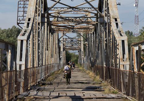 Alte Eisenbrücke in Halytsch (Oblast Iwano-Frankiwsk, Ukraine) über die Dnister:Die Straßenoberfläche ist in einem sehr schlechten Zustand, Löcher werden lediglich durch Holzplanken abgedeckt. Autos nutzen die neuere Brücke ca. 100 m westwärts.