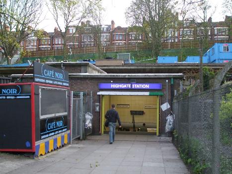 Highgate tube station eastern entrance on Priory Gardens : Note remains of the high-level station behind the entrance, and Archway Road (the A1) on the embankment in the background.