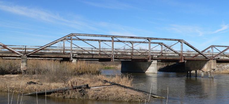 One of the three spans of the Kilgore Bridge in Buffalo County, Nebraska:The bridge crosses the north channel of the Platte River beside Nebraska Highway 10. The picture was taken facing northwest (upstream). The Pratt pony truss bridge was built in 1915 by the Nebraska Department of Roads. Highway 10 now crosses the river on a concrete bridge just upstream. Until 2009, the Kilgore Bridge carried local traffic to a frontage road beside Interstate 80 north of the river; however, it is now closed to motor traffic. The bridge is listed in the National Register of Historic Places.