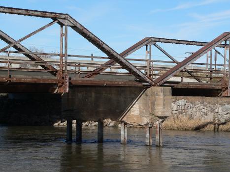 Detail of Kilgore Bridge in Buffalo County, Nebraska:The bridge crosses the north channel of the Platte River beside Nebraska Highway 10. The picture was taken facing northwest (upstream). The Pratt pony truss bridge was built in 1915 by the Nebraska Department of Roads. Highway 10 now crosses the river on a concrete bridge just upstream. Until 2009, the Kilgore Bridge carried local traffic to a frontage road beside Interstate 80 north of the river; however, it is now closed to motor traffic. The picture shows damage to one of the bridge's piers. The bridge is listed in the National Register of Historic Places.