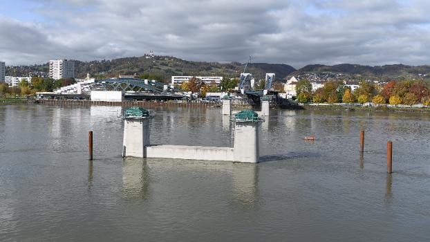 Neubau Eisenbahnbrücke Linz:Die Neue Linzer Donaubrücke (Projektname) ist der Ersatz der 2016 abgetragenen Eisenbahnbrücke. Sie wurde nach einem Design des Pariser Architekturbüros Mimram gebaut.