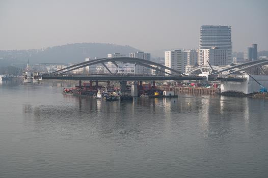 Neubau Eisenbahnbrücke Linz:Die Neue Linzer Donaubrücke (Projektname) ist der Ersatz der 2016 abgetragenen Eisenbahnbrücke. Sie wurde nach einem Design des Pariser Architekturbüros Mimram gebaut. 
Der Transport der Brückenelemente vom Vormontageplatz auf die Brückenpfeiler erfolgte mit Hilfe zweier Pontons und Schubschiffen.