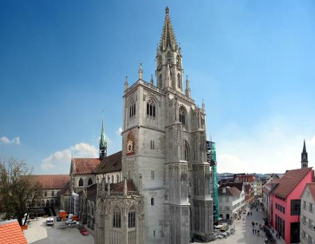 Cathédrale Notre-Dame de Constance et ses environs, vus du nord-ouest : Assemblage de plusieurs photographies. On distingue, de gauche à droite: le cloître (au second plan, à gauche)
; le bras septentrional du transept, avec flèche de croisée
; la chapelle Welser (tout à l'avant-plan)
; les clochers nord et sud (au milieu de la photo, avec échafaudages)
; la place de la Cathédrale (Münsterplatz), à gauche, et la rue Wessenberggasse, à droite
; la façade rouge du centre culturel 'am Münsterplatz' 
; le clocher de l'église Saint-Étienne (St. Stephan, à l'arrière-plan à droite, contre le bord droit de la photo).